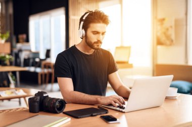 Freelancer sakallı adam masada oturan laptop müzik dinlemek.