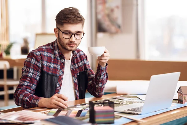 Freelancer hombre dibujo en plan en el ordenador portátil sentado en el escritorio . — Foto de Stock