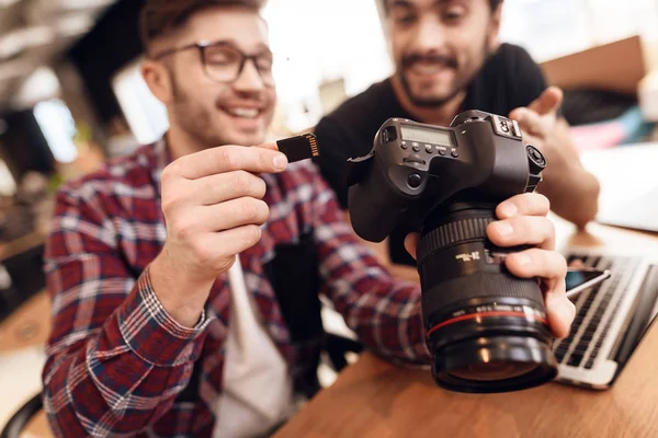 Two freelancer men taking out memory card at laptop at desk. — Stock Photo, Image