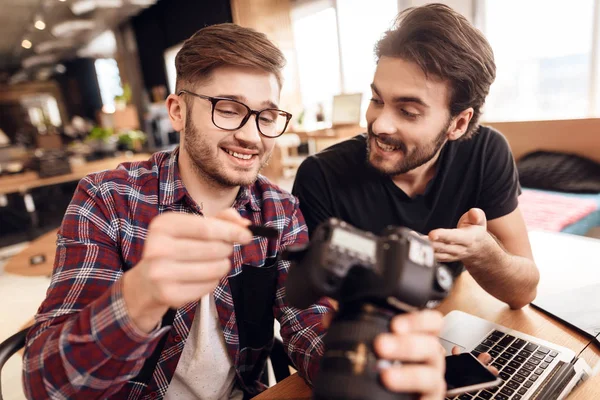 Dois homens freelancers tirando cartão de memória no laptop na mesa . — Fotografia de Stock