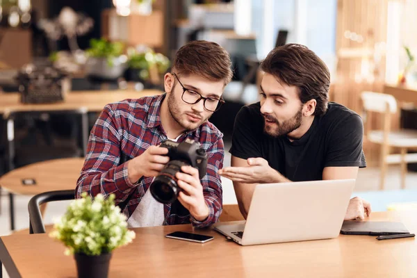 Dos hombres freelancer mirando fotos en el portátil en el escritorio . — Foto de Stock