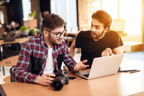 Dos hombres freelancer mirando fotos en el portátil en el escritorio . — Foto de Stock