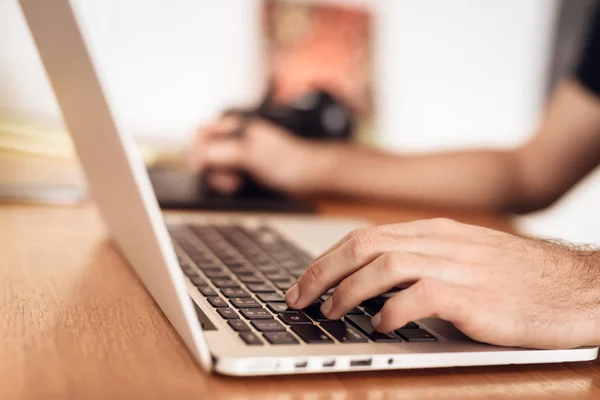 Primer plano freelancer barbudo hombre dibujo en el portátil sentado en el escritorio . — Foto de Stock