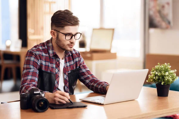 Freelancer człowieka rysunek w laptopie siedząc przy biurku. — Zdjęcie stockowe