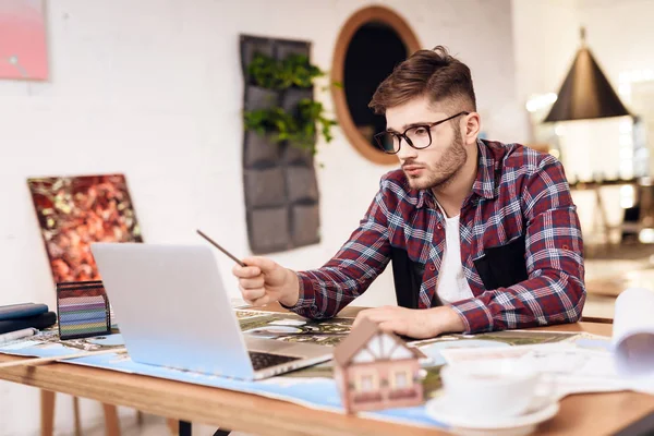 Freelancer hombre dibujo en plan en el ordenador portátil sentado en el escritorio . — Foto de Stock
