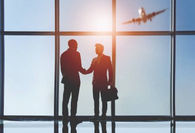İki genç işadamları görünümünü siluet modern ofis panoramik pencereli bekliyoruz