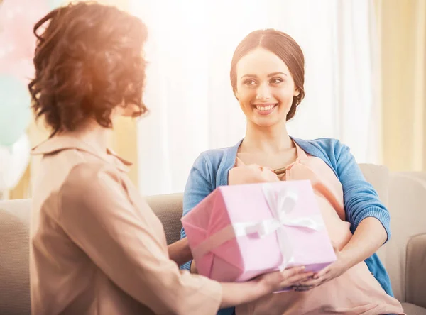 Young woman gives a gift to her pregnant friend — Stock Photo, Image