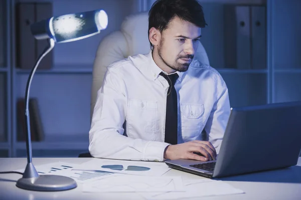 Empresario con laptop. Joven hombre de negocios está mirando el ordenador portátil en su oficina — Foto de Stock