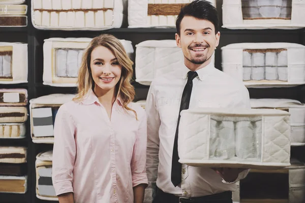 Good choice. The young salesman and the customer with quality mattresses in the store — Stock Photo, Image