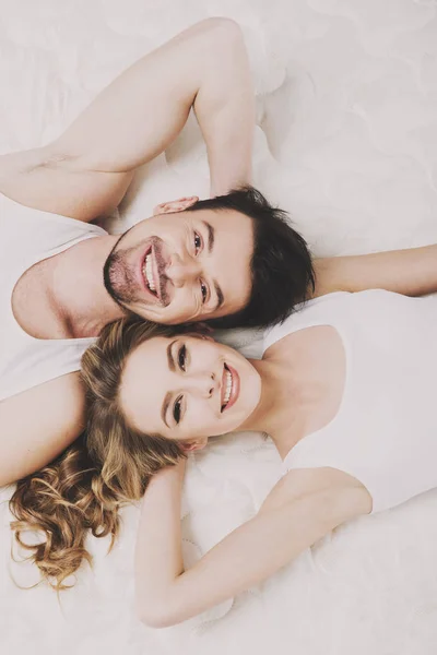 Vista superior de la joven pareja hermosa están acostados en el colchón de calidad — Foto de Stock