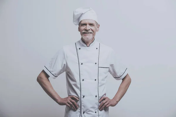 Jefe de cocina masculino senior en uniforme sobre fondo gris — Foto de Stock