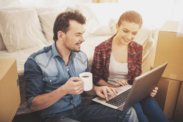 젊은 행복 한 커플 노트북으로 아파트에 대 한 검색. 새로운 거주의 구매 이동, — 스톡 사진