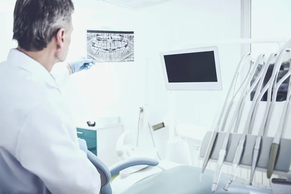 Πορτρέτο του μια ακτινογραφία analising ανώτερος οδοντίατρος στο οδοντιατρείο — Φωτογραφία Αρχείου