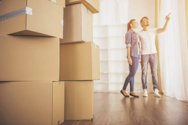 La joven pareja feliz mirando alrededor de su nuevo apartamento. Traslado, compra de nueva vivienda — Foto de Stock