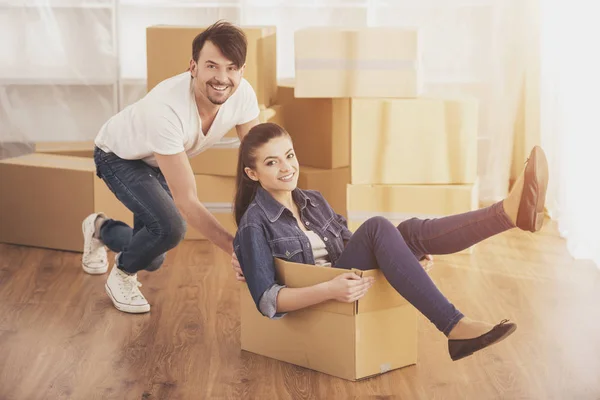 Die junge glückliche Frau, die in einem Karton sitzt. Umzug, Kauf einer neuen Wohnung — Stockfoto