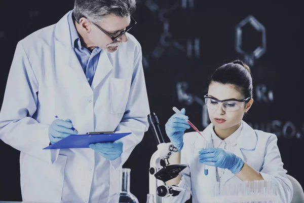 Ledande kemi professor och hans assistent arbetar i laboratoriet — Stockfoto