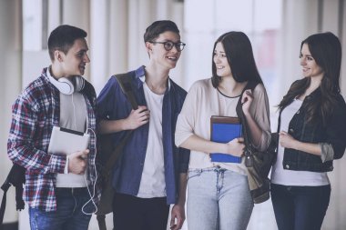 Mutlu genç öğrenci bir üniversitede konuşma grubu.