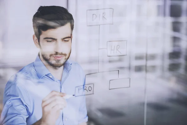 Joven hombre de negocios guapo dibujo en la pantalla de vidrio en la oficina —  Fotos de Stock