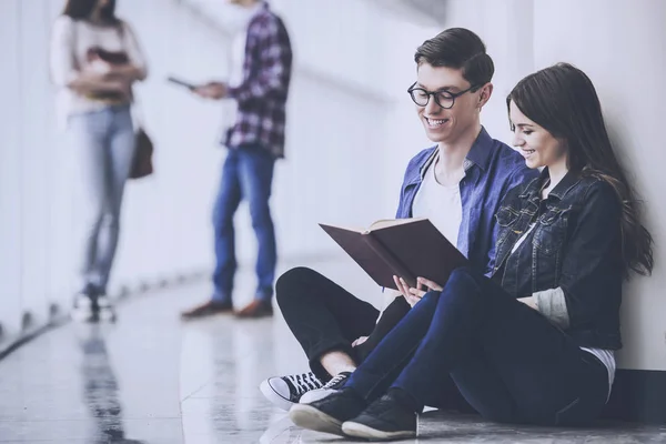 Oturma Üniversite Koridorunda Bir Kitap Okuma Öğrenciler Genç Çift — Stok fotoğraf