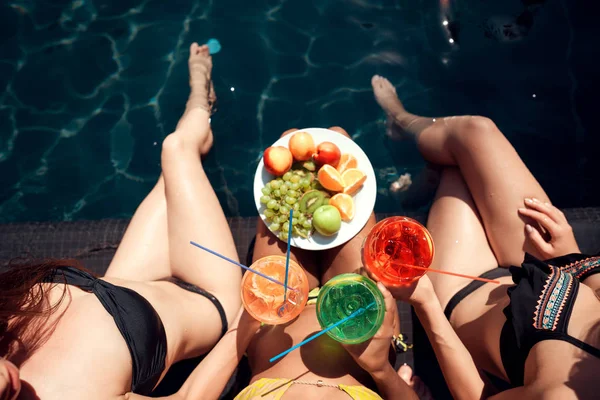위에서 수영복을 소녀들은 여름에 수영장에서 과일을 칵테일을 마신다 수영장 파티에 — 스톡 사진