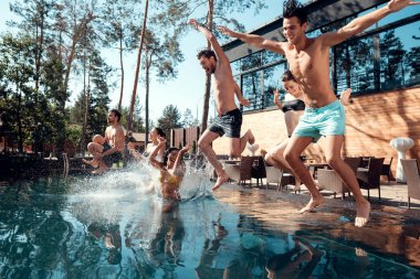 Mutlu genç insanların su sıçramalarına şekillendirme havuza atlama şirket. Havuz partisi konsepti. Tatil aquapark, yüzme havuzunda.