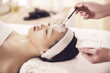 Genç Asyalı kadın Güzellik Salonu yüz maskesi alma için Spa terapi