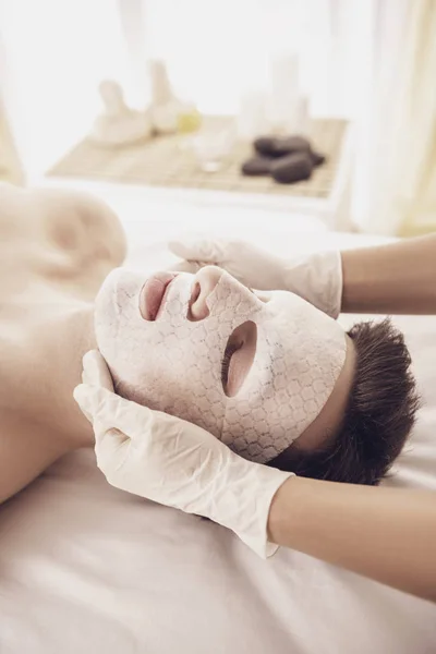 Спа-терапия для молодой азиатки, получающей маску для лица в салоне красоты — стоковое фото