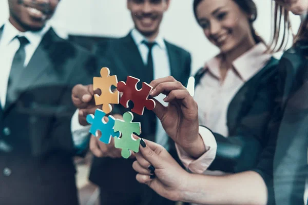 Empresários juntam partes do quebra-cabeça comum. Conceito de negociações bem sucedidas . — Fotografia de Stock