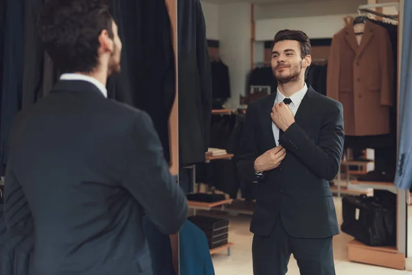 Kendine güvenen neşeli adam kravat erkekler iş giyim mağazası showroom bağları. — Stok fotoğraf