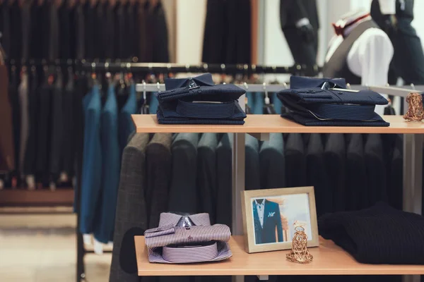 Starannie złożone koszule leżą na półkach sklepu ubrania biznesowe. Garderoba. — Zdjęcie stockowe