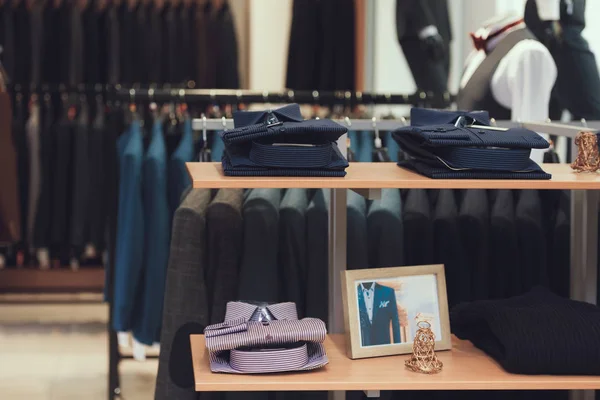 Sorgfältig gefaltete Hemden liegen in den Regalen eines Bekleidungsgeschäfts. Garderobe. — Stockfoto