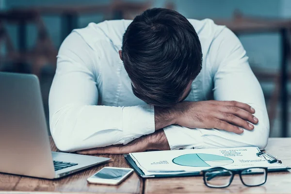 Indisk affärsman sover på jobbet, sitter vid bord. — Stockfoto