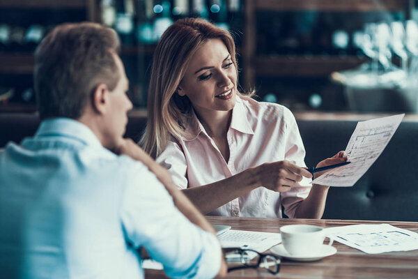 Успешная женщина-дизайнер обсуждает проект с коллегой за обедом в кафе
.