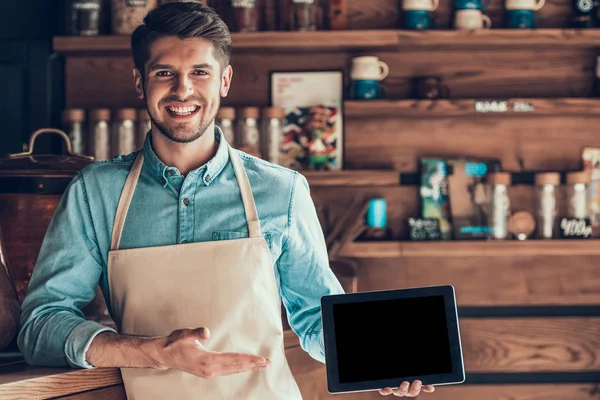 Retrato de barista exitoso en delantal con tableta en cafetería . —  Fotos de Stock