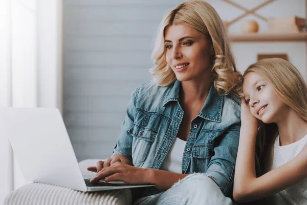 Femme blonde avec petite fille naviguant sur les pages Internet sur ordinateur portable . — Photo