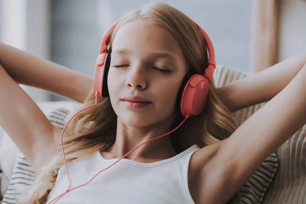 Tienermeisje luistert naar muziek op koptelefoon, ogen sluiten. — Stockfoto