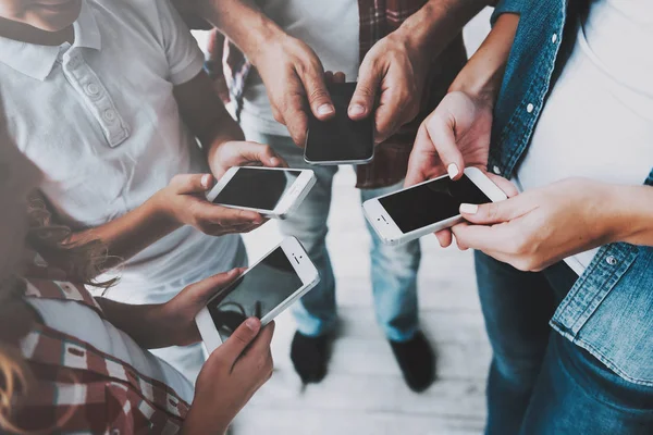 Grupp människor står i cirkel hålla smartphones i händer. — Stockfoto