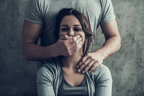 Man closes by hand mouth of oppressed woman. — Stock Photo, Image