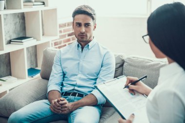 Genç adam psikolog resepsiyonda üzgün.