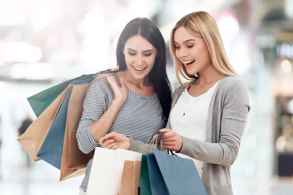 Jonge vriendinnen met boodschappentassen zijn winkelen bij winkelcentrum. — Stockfoto