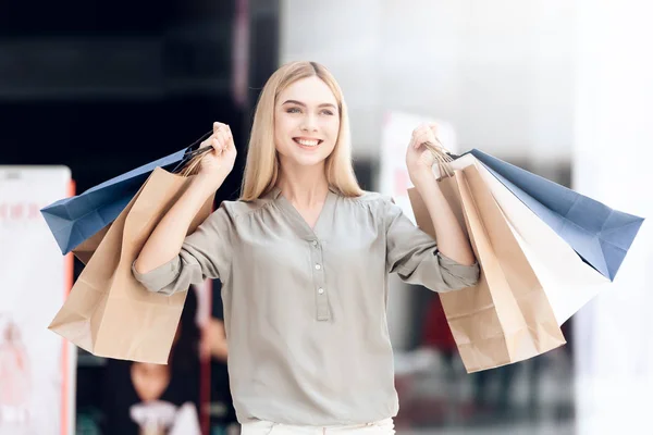 Joyeux blond avec des sacs à provisions au centre commercial. Vente . — Photo