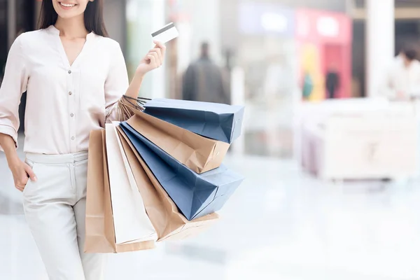 Glückliche Brünette mit Einkaufstaschen im Einkaufszentrum. Verkauf. — Stockfoto