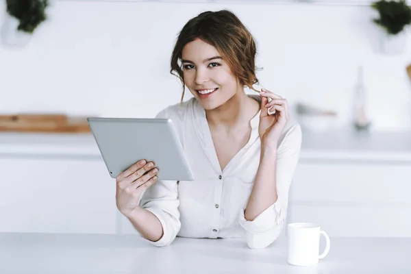 Jeune femme avec une tasse de café regarde les nouvelles financières . — Photo