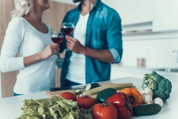 Casal amoroso com copos de vinho preparar o café da manhã juntos . — Fotografia de Stock