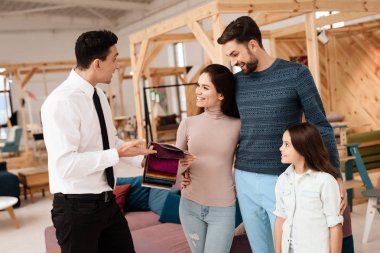 Mobilya mağazası Müdürü kumaşlar için mobilya döşeme örnekleri içerir. Ona bir anne, baba ve kız vardır. Onlar mobilya alıcılar vardır.