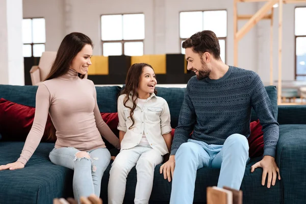 年轻的家庭与小女孩坐在沙发上 他们一起来到家具店为房子选择新家具 — 图库照片