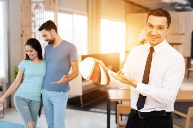 Mobilya mağazası Müdürü kumaşlar için mobilya döşeme örnekleri içerir. Yanına bir adam ve bir kız - mobilya alıcılar vardır.