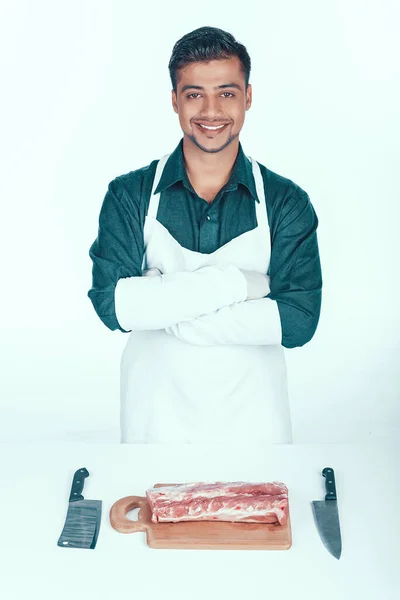 Carnicero guapo en delantal va a cortar carne . — Foto de Stock