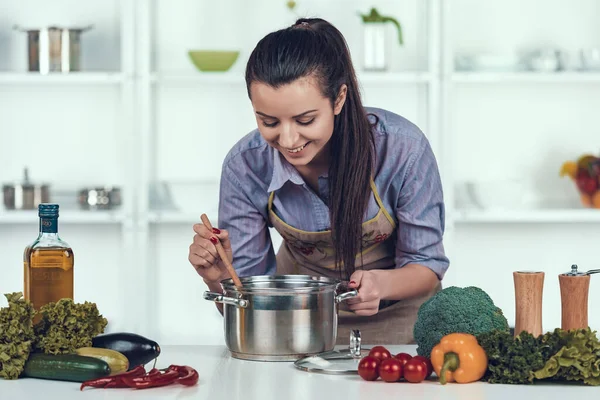 Jovem dona de casa cozinhar almoço cozinha luxuosa . — Fotografia de Stock