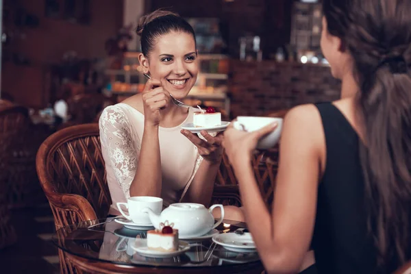 Ευτυχισμένες γυναίκες έχουν τσάι και κέικ στο εστιατόριο. — Φωτογραφία Αρχείου